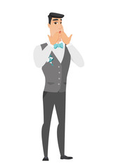 Shoked caucasian groom covering his mouth.