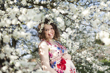 Blooming garden, Beautiful pregnant woman 
