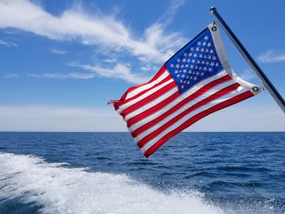 American flag on boat with boating wake on Lake Michigan - Powered by Adobe