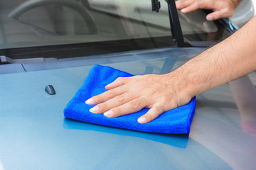 Hand cleaning car bonnet with microfiber cloth