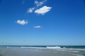 Fototapeta na wymiar sea waves at beach and blue sky