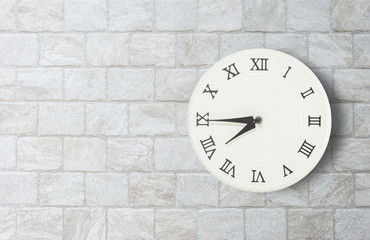 Closeup white clock for decorate show a quarter to eight o'clock or 7:45 a.m. on old brick wall textured background with copy space in interior concept