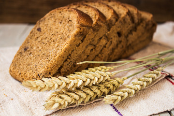 homemade bread and wheat on a light wooden background