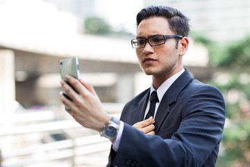 Fototapeta premium Young asian businessman outdoors
