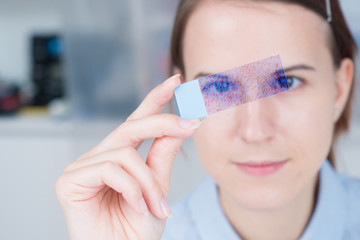 young woman scientific / female student researcher looking microscope slide  in a laboratory.