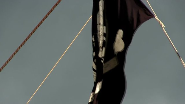 Tattered pirate flag waves in wind
