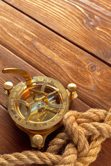 Compass and rope on wooden table. close up