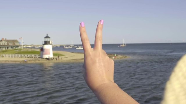 Young Woman Holds Up Peace Sign, From Moving Boat, Beautiful View Of Brant Point Lighthouse On Nantucket Island