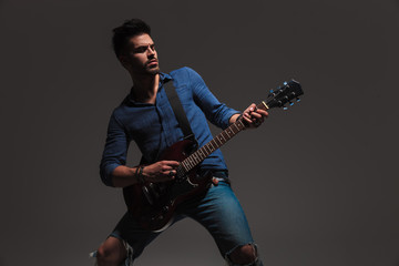 young man playing his electric guitar