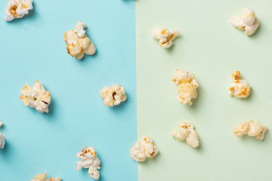 The popcorn in paper cup on green and blue background.