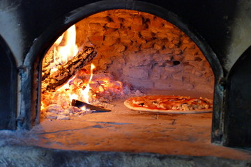Pizza in wood fired oven - traditional, rustic way of making pizza