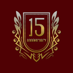 Fifteenth anniversary vintage logo symbol. Golden emblem with numbers on shield in wreath.
