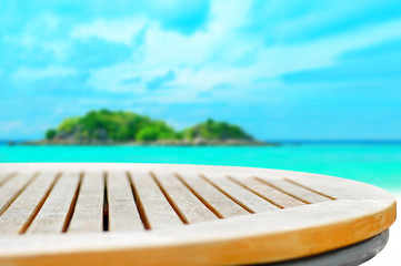 Round wood table top on blur sea and island background