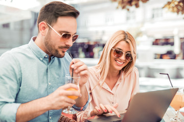 Couple in love using laptop in the city.
