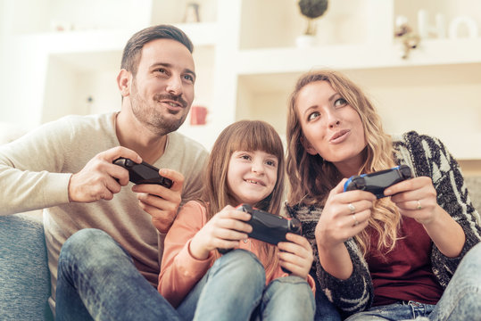 Young family sitting and playing video games