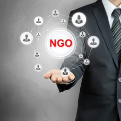 NGO (or Non-Governmental Organization) sign on businessman hand