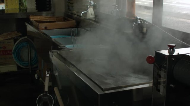 さぬきうどんづくり　厨房のうどん釜から湯気が立っている