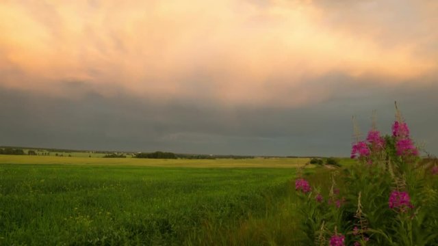 Sunset over the field after the storm. Time laps landscape