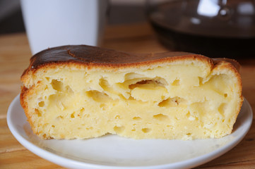A piece of curd cake close-up. Coffee in the background