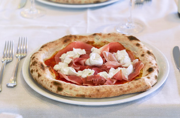 Italian Pizza with ham and mozzarella cheese. Close up table set interior restaurant
