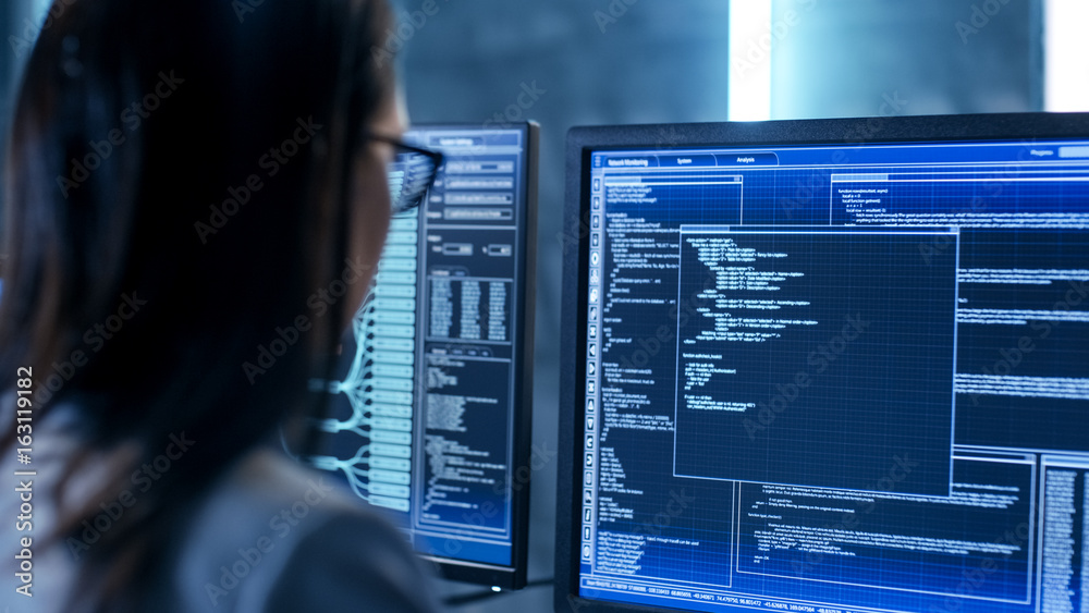 Leinwandbilder close-up shot of female it engineer working in monitoring room. she works with multiple displays.