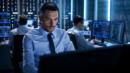 Close-up of Technical Engineer Working on His Computer With Multiple Displays in Monitoring Room....