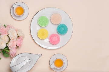 Sweet color of snow skin mooncake. Traditional mid autumn festival foods with tea on table setting.