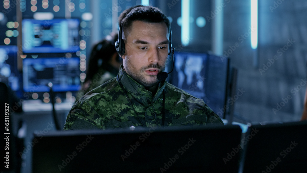 Leinwandbilder close-up shot of military technical support professional gives instructions using headset. he's in a