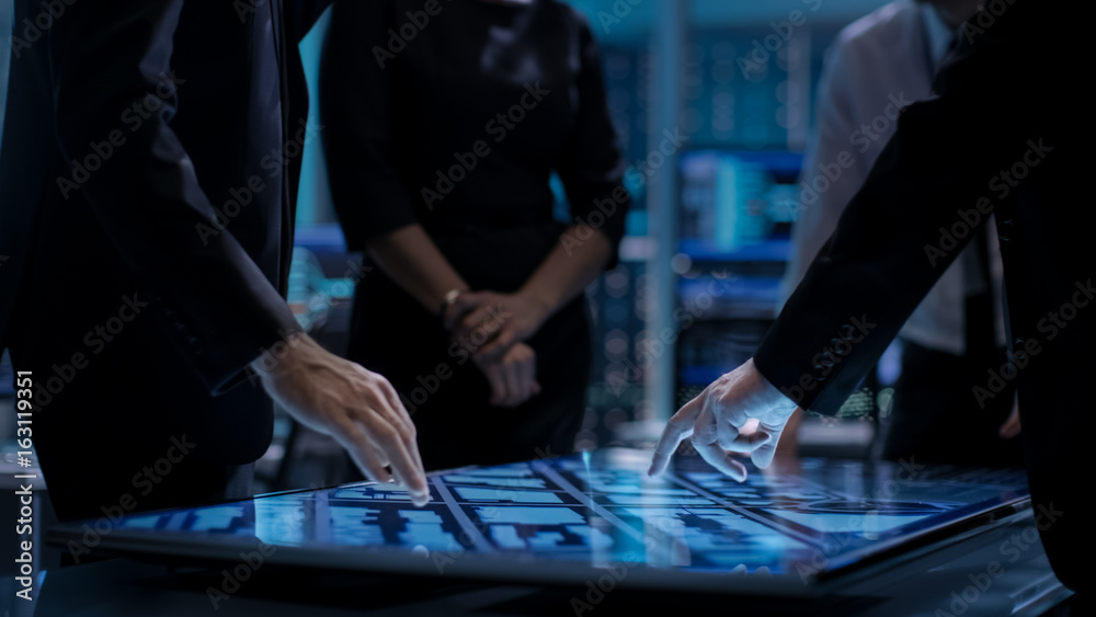 Poster corporate managers working at the table in monitoring room. room is full of state of the art technol