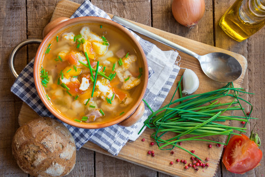 Vegetable soup with bread on wood
