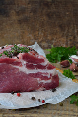 raw piece meat of pork and spices marinade on wooden background. For steak, roasting, stewing. Space for text
