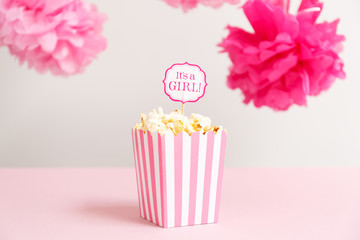 It's a girl sign in a popcorn bag at the baby shower party.  Baby shower celebration concept