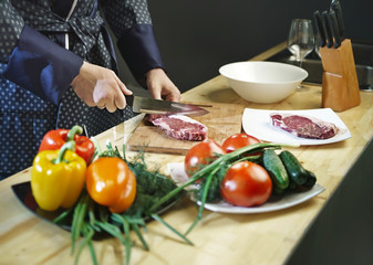 Obraz na płótnie Canvas Man cuts the meat with a knife