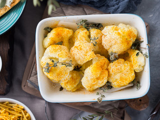 Baked cauliflower with turmeric and marjoram on rustic background. Lunch with vegetables