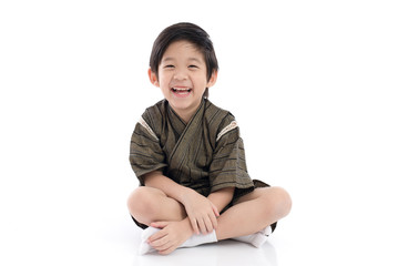 Happy asian boy in kimono sitting