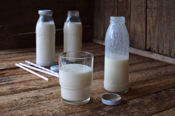 Sour-dairy drink or yoghurt in bottle that come from the kefir grains and milk on wooden background. Photographed with natural light