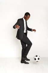 Foto op Canvas Serious businessman in suit playing football © Prostock-studio