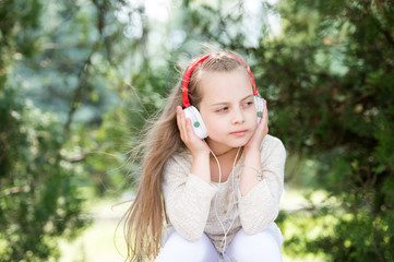 Cute little girl enjoying music using headphones