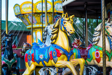 Beautiful horse Christmas carousel in a holiday park. Horses on a traditional fairground vintage...