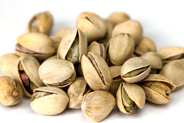 Heap of pistachio nuts isolated on white background close up