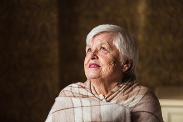 Portrait of an old woman are bundled up in blanket