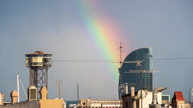 timelapse shot of the rooftops of barcelona shot from a terrace in the centre of the city. the weather this day was a mix of sun and storms create a beautiful rainbow over the skyline