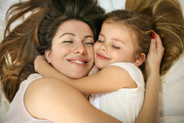 Mother and daughter in the bed together.