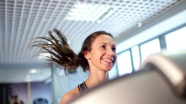 A beautifull brunette girl running on the treadmill