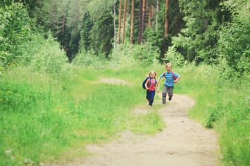 happy little boy and girl run to school