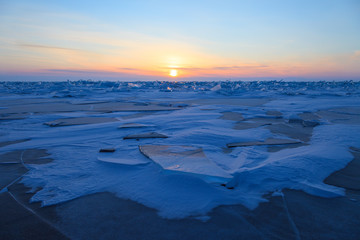 Beautiful formation on ice field of lake Baikal in winter on sunrise
