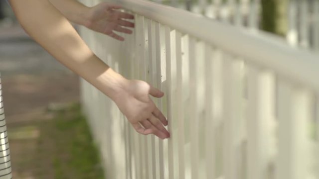 Closeup Of Hands Touching Fence, As Teen Girls Walk Toward Camera