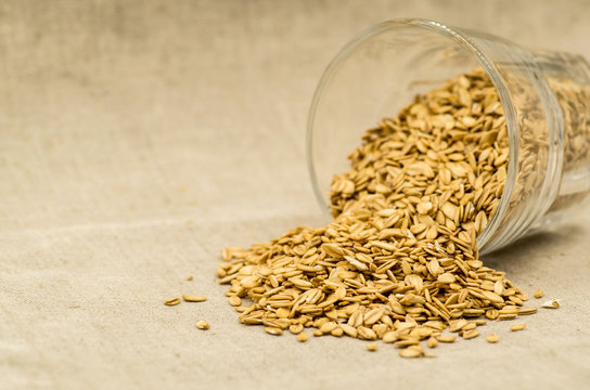 oatmeat porridge flakes in a crystal glass on linen tablecloth