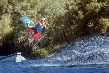 Professional athlete during a wakeboard trick on the water.