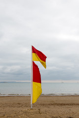 Red and yellow lifeguards flag on beach